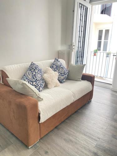 un canapé avec des coussins dessus dans un salon dans l'établissement Chic Appartement 2 bedrooms PHANTHEON NOTRE DAME, à Paris