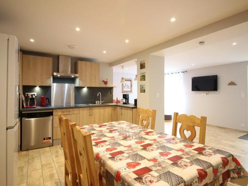 une cuisine avec une table et des chaises ainsi qu'une cuisine avec une table et une table dans l'établissement Charmant T2 au Mont-Dore, parking privatif, proche thermes, classé 2 étoiles - 4 couchages - FR-1-415-124, à Le Mont-Dore