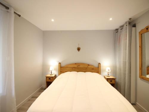 une chambre avec un grand lit blanc avec deux lampes dans l'établissement Charmant T2 au Mont-Dore, parking privatif, proche thermes, classé 2 étoiles - 4 couchages - FR-1-415-124, à Le Mont-Dore