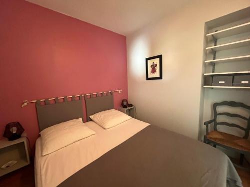 une chambre avec un lit et un mur rouge dans l'établissement T2 de charme avec parking privé, à 100m de la plage, en plein cœur d'Arcachon - FR-1-374-216, à Arcachon