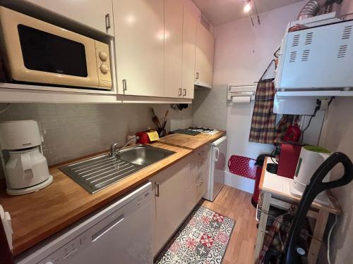 une petite cuisine avec un évier et un micro-ondes dans l'établissement T2 de charme avec parking privé, à 100m de la plage, en plein cœur d'Arcachon - FR-1-374-216, à Arcachon
