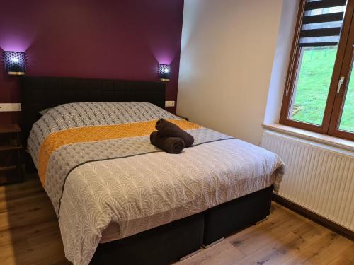 Un dormitorio con una cama con un osito de peluche. en Gite au petit Donon, en Rothau