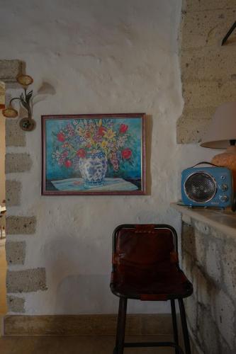 a painting of a vase on a wall with a chair at Alaçatı Taş Otel in Alacati