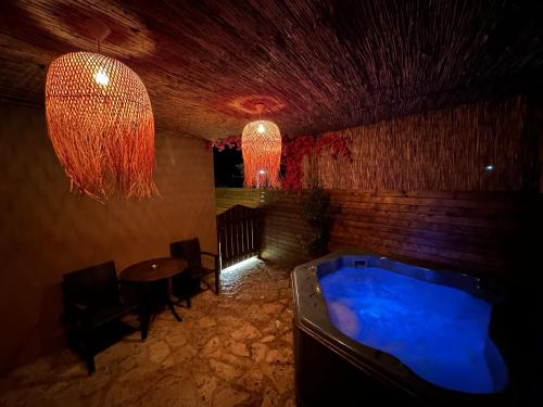 a room with a hot tub and a table and a chandelier at 4 MOUNTAIN HILLS in Méga Khoríon