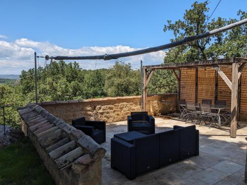 un patio avec un canapé, une table et des chaises dans l'établissement Le grand chêne vert - Bagnols-sur-Cèze, à Bagnols-sur-Cèze