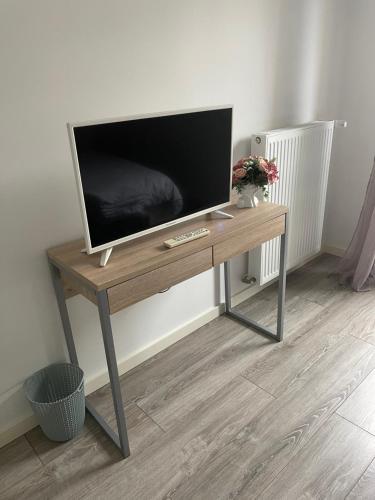 a television on a wooden table in a room at Luxury apartment near CDG & Parc Asterix in Vémars
