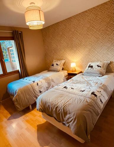 une chambre avec deux lits et un lustre dans l'établissement Appartement situé en rez de jardin avec piscine privée en été, à Séez