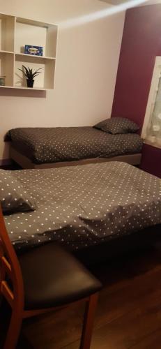 - deux lits jumeaux dans une chambre avec une chaise dans l'établissement Le 47 B&B Single, au Mans