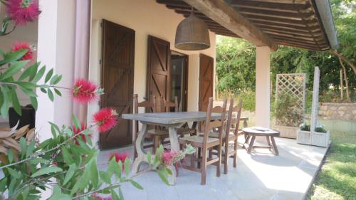 a table and chairs on a patio with pink flowers at Capalbio - Retreat in Capalbio