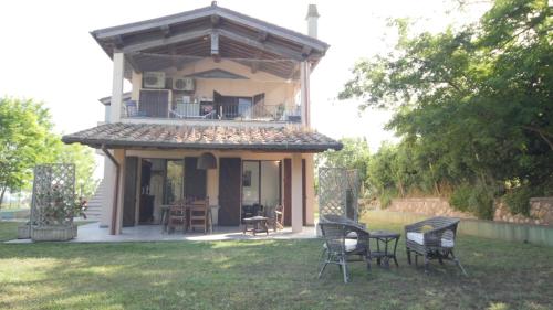 a house with a balcony and chairs in a yard at Capalbio - Retreat in Capalbio