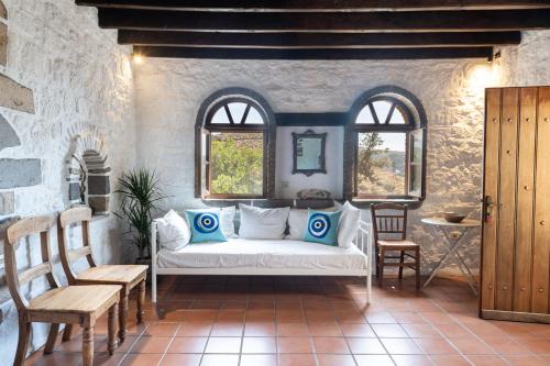 a living room with a white couch and two windows at Villa Margarita Studio in Patmos