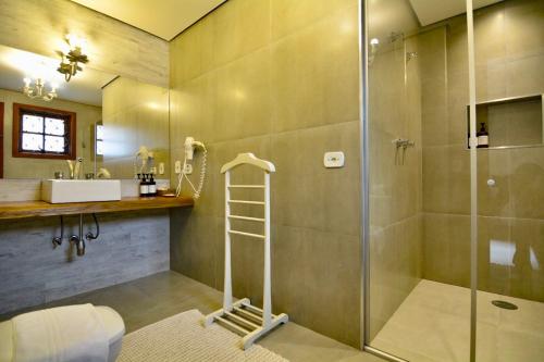 y baño con ducha y lavamanos. en Pousada Da Pedra, en Campos do Jordão