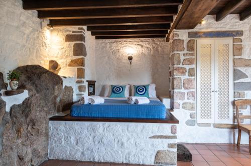 a bedroom with a bed in a stone wall at Villa Margarita Studio in Patmos