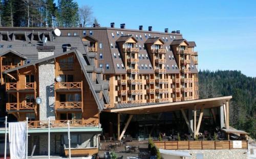 a large building with a staircase on top of it at Apartmani VinVucko Jahorina u sklopu aparthotela Vucko privatni apartmani in Jahorina