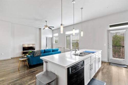 a kitchen and living room with a blue couch at Modern Austin 2BR 2B Apt with Pool Parking & WIFI in Austin