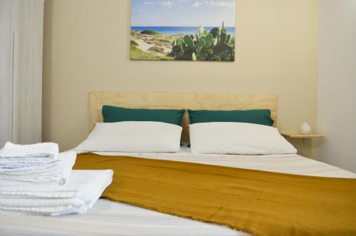 1 cama con 2 almohadas y una foto del océano en B&B la Quiete, en Leverano