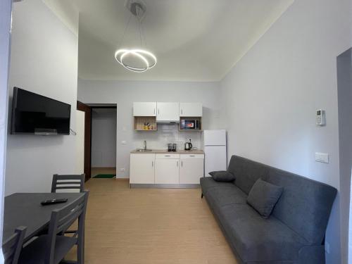 a living room with a couch and a table and a kitchen at Casa al mare in Savona