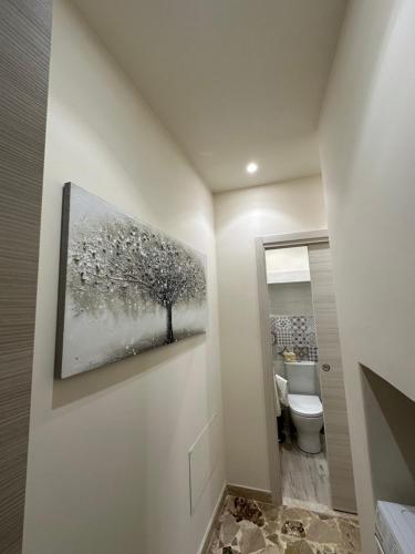 a bathroom with a painting on the wall and a toilet at Sotto l'Arco in Acireale