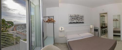 a white room with a bed and a balcony at Donna Adriana Rooms in Agropoli