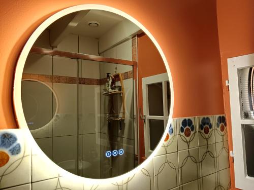 a bathroom with a round mirror on the wall at B&B à la Campagne in Puynormand