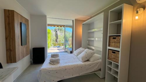 - une chambre avec un lit et une grande porte en verre dans l'établissement La perle des Estivales, STUDIO avec coin nuit enfants, parking et piscine , à 20min à pied port et plage, à Sanary-sur-Mer
