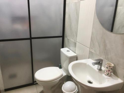 een badkamer met een wit toilet en een wastafel bij Departamento al lado de Fortis in Ciudad del Este