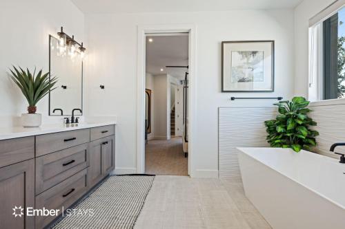 a bathroom with a tub and a sink and a mirror at Desert Dream at Desert Color (by Ember Stays) in St. George
