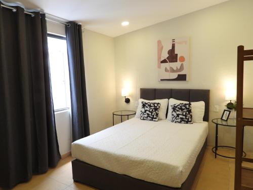 a bedroom with a bed with two pillows and a window at Singular Reforma in Mexico City