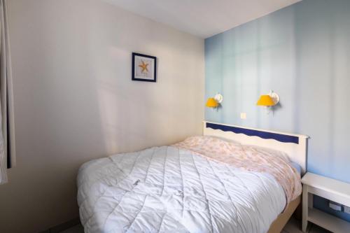- une chambre avec un lit et deux lumières sur le mur dans l'établissement Résidence Port Bourgenay - maeva Home - Appartement 2 Pièces 5 Personnes - Sélection MAE-8605, à Talmont-Saint-Hilaire