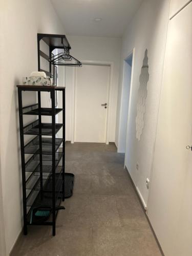 a hallway with a black shelf and a white door at Hive - 3 ZW in Ansbach inkl TV und große Balkon in Ansbach