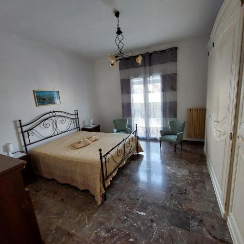 a bedroom with a bed and two chairs and a window at Casa vacanze Milena in Milena