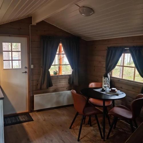 a room with a table and chairs and a window at Tørfoss Gård, Hytte utleie, Campingvogn og bobil plasser in Potka