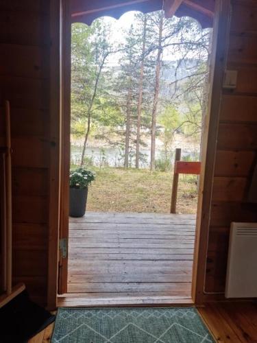 an open door to a wooden porch with a view at Tørfoss Gård, Hytte utleie, Campingvogn og bobil plasser in Potka