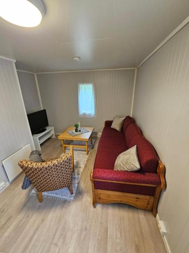 a living room with a couch and a table at Tørfoss Gård, Hytte utleie, Campingvogn og bobil plasser in Potka