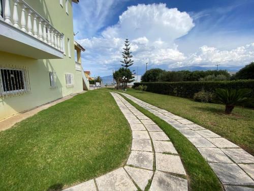 a walkway in a yard next to a house at Helen's Seaside Apartment in Nafpaktos