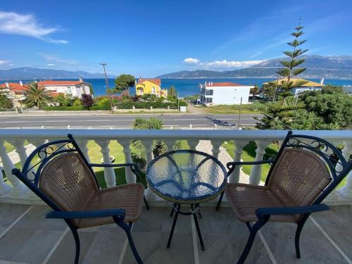 two chairs and a table on a balcony at Helen's Seaside Apartment in Nafpaktos
