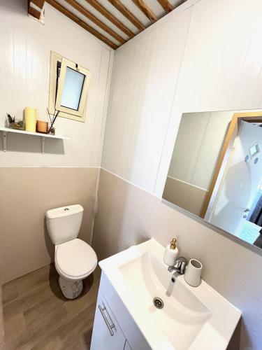a white bathroom with a toilet and a sink at Ramban Emerald in Haifa