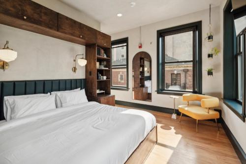 a bedroom with a large white bed and a chair at Society Hill Hotel in Philadelphia