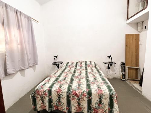 Una cama en una habitación con una manta. en Casa en Piriapolis, en Piriápolis