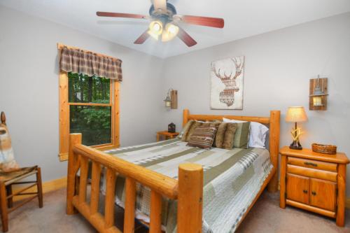 a bedroom with a bed and a ceiling fan at Large Cabin to Enjoy in Coosawattee River Resort in Ellijay