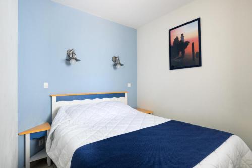 une chambre avec un lit avec une couverture bleue et blanche dans l'établissement Résidence Port Bourgenay - maeva Home - Appartement 2 Pièces 5 Personnes - Sélection MAE-3254, à Talmont-Saint-Hilaire