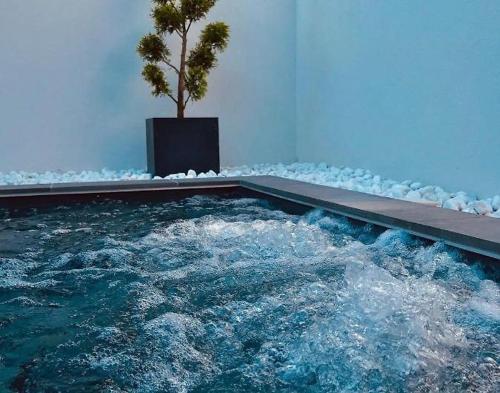 une piscine avec un arbre au milieu dans l'établissement Villa 75m2 avec Piscine et Jacuzzi privés, Sauna et Home-Cinéma à 800m des Commodités, à La Baule