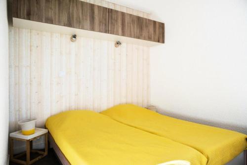 - une chambre avec un lit jaune et une table de chevet dans l'établissement Résidence Port Bourgenay - maeva Home - Appartement 2 pièces 4 personnes - Sélection MAE-1654, à Talmont-Saint-Hilaire