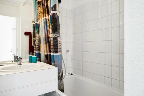 une salle de bain blanche avec un lavabo et une baignoire dans l'établissement Résidence Port Bourgenay - maeva Home - Appartement 2 pièces 4 personnes - Sélection MAE-1654, à Talmont-Saint-Hilaire