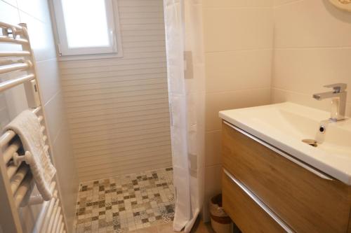 une salle de bain avec un lavabo et une douche dans l'établissement Les Pivoines Maison climatisée, proximité mer, plages et forêts, à Saint-Hilaire-de-Riez