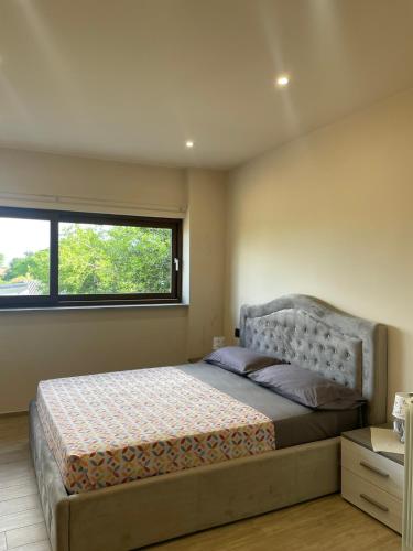 a bedroom with a large bed with a window at Maison Du Bois in Rivarolo Canavese