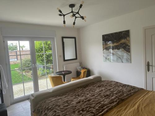 a bedroom with a bed and a table and windows at Villa kleinwellness in Lanaken