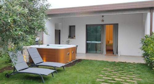 a hot tub in a yard with two chairs at I SECOLARI in Sannicandro di Bari