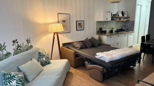 salon z kanapą i stołem w obiekcie Studio pied dans l'eau - WIFI- Piscine w mieście Santa-Lucia-di-Moriani