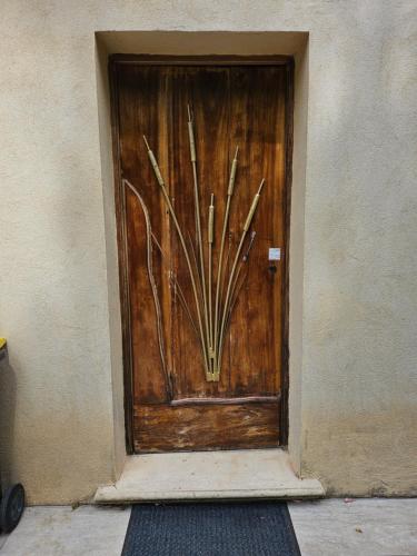 a wooden door with a painting of sticks on it at Appartement de vacances au 1er étage 45m2 in Antibes